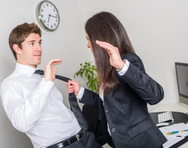 Bully Businesswoman Holding Colleague's Necktie